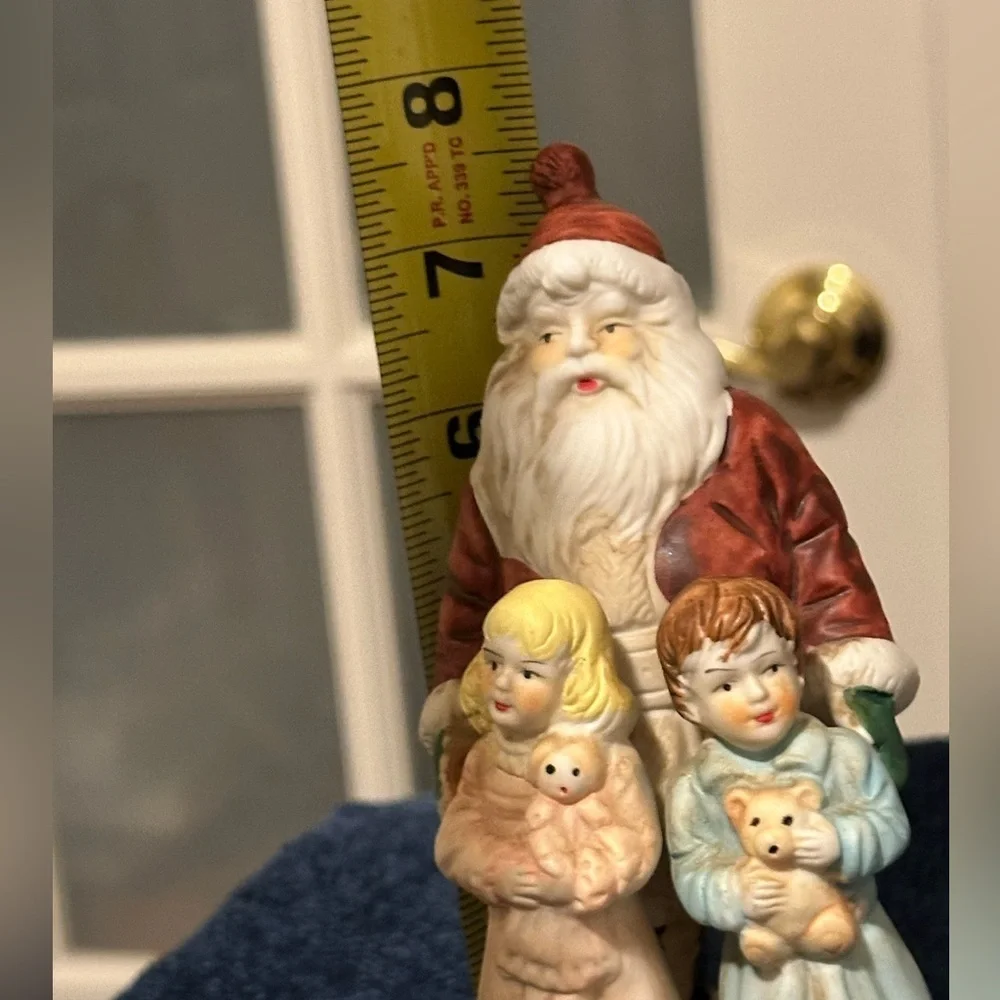 Beautiful Santa hugs 2 small children and plays Santa Claus is Coming to Town.